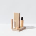 Elegant display of foundation, concealer, and sponge for a clean beauty setup on a white surface.