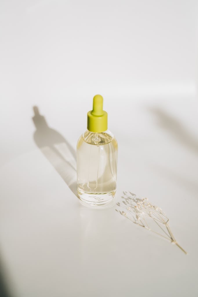 Elegant minimalist shot of an essential oil bottle with a dropper against a soft background.
