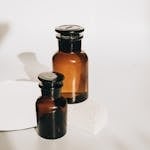 Stylish set of amber glass bottles with a minimalist touch, perfect for cosmetics or essential oils.
